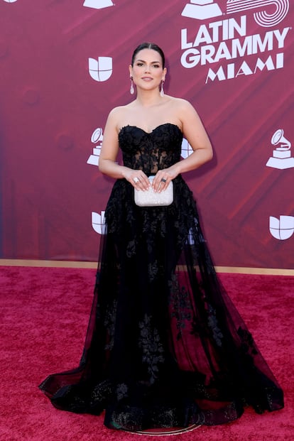 Karina Banda, elegante con un vestido negro palabra de honor.