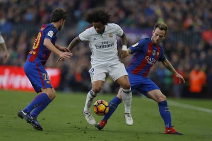 Marcelo (centro), del Real Madrid, flanqueado por Rakitic (derecha) y Sergi Roberto del FC Barcelona.