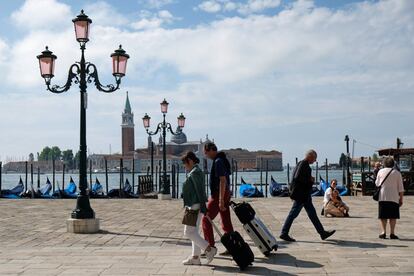 Una pareja arrastra sus maletas cerca de la plaza de San Marcos de Venecia. Italia inicia, mañana lunes, su fase 3 de la desescalada tras el cierre total por la pandemia de coronavirus el pasado 9 de marzo.