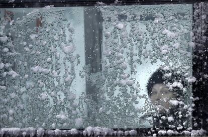 Una mujer mira por la ventana nevada de un autobús en Bucarest (Rumanía), el 17 de enero de 2016.