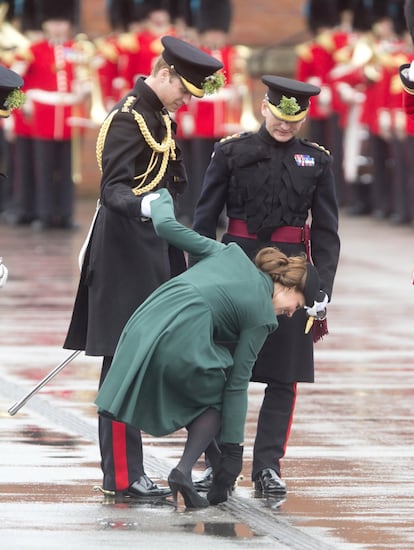 La Duquesa de Cambridge recibe la ayuda del Príncipe Guillermo, Duque de Cambridge, después de que su tacón se atascara en una rejilla durante el Desfile del Día de San Patricio de la Guardia Irlandesa, el 17 de marzo de 2013, en Aldershot, Inglaterra.