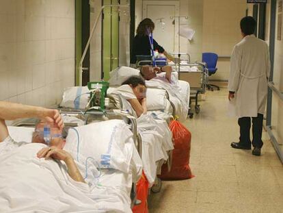 Varios pacientes esperan ayer en un pasillo de la zona de urgencias del hospital La Paz.