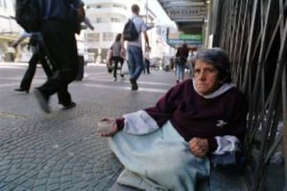 Una anciana indigente pide limosna a los transeúntes del centro de Montevideo. EFE/Archivo
