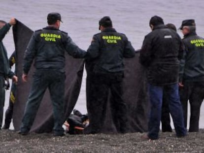 La Guardia Civil tapa un cadáver en la playa del Tarajal, en febrero de 2014.