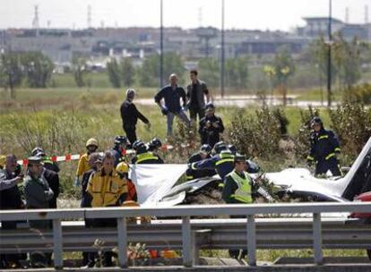 Los bomberos retiran parte del fuselaje de la avioneta siniestrada junto a la M-40.