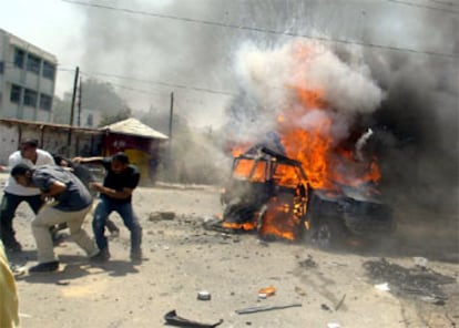 Varios palestinos huyen cuando el vehículo, del que se acaba de bajar Rantisi, es alcanzado por un misil.