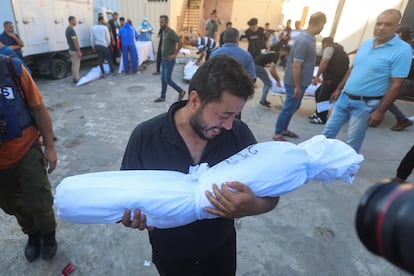 Un palestino lleva el cuerpo de un niño muerto en ataques israelíes, en el hospital Shuhada Al-Aqsa, en el centro de la Franja de Gaza, este martes.