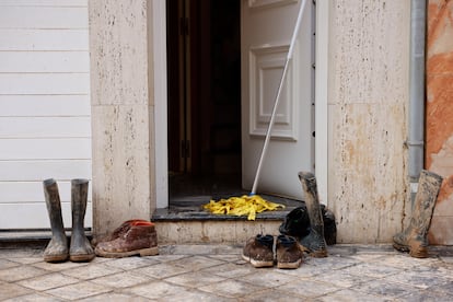 Detalle de varias botas y zapatos cubiertos por el lodo en Sedaví (Valencia), este lunes.