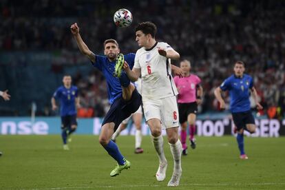 El italiano Domenico Berardi, a la izquierda, y el inglés Harry Maguire luchan por el balón durante la final de la Eurocopa 2020 en el estadio de Wembley en Londres.