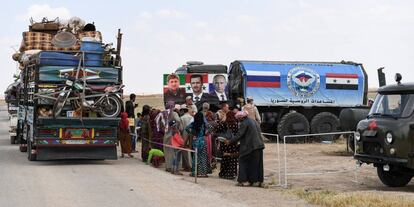 Un grupo de desplazados sirios, en un 'checkpoint' de militares rusos, en la provincia de Idlib.