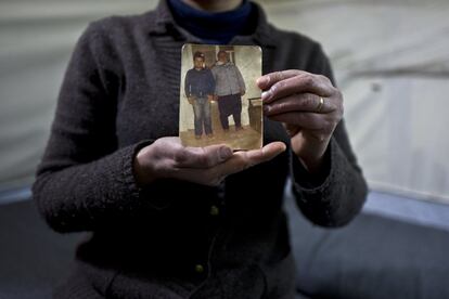 In this Wednesday, Jan. 18, 2017 photo, Habeeba Waqas, 40, a Syrian refugee from Aleppo, holds a photograph showing her husband Mohammed and her father in law Suliman at her tent in Frakapor refugee camp on the outskirts of the northern Greek city of Thessaloniki. "This is the only memory that I carried with me from Syria, my husband was young and handsome in this picture." Habeeba said. (AP Photo/Muhammed Muheisen)