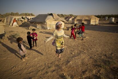 FILE - In this Sunday, July 19, 2015 file photo, Syrian refugee girl, Zubaida Faisal, 10, skips a rope while she and other children play near their tents at an informal tented settlement near the Syrian border on the outskirts of Mafraq, Jordan. UNICEF said Monday, March 14, 2016 that one-third of Syrians under the age of 18, or about 3.7 million, were born since an uprising against President Bashar Assad erupted in 2011 and escalated into a civil war. (AP Photo/Muhammed Muheisen, File)