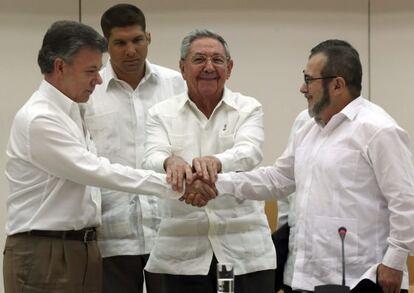 El presidente de Cuba, Raúl Castro (en el centro), aprieta las manos del presidente de Colombia Juan Manuel Santos (a la izquierda) y el máximo líder de las FARC, Rodrigo Londoño, 'Timochenko', en La Habana el pasado miércoles.