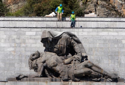 Dos operarios durante los trabajos de desmontaje de La Piedad en el Valle de los Caídos.