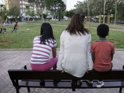 Los dos menores flanquen a su madre en un parque de Sevilla.