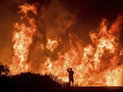 Um homem observa desde a estrada o incêndio de Ventura, Califórnia, na quinta-feira.