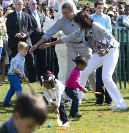 El presidente Barack Obama y su mujer, Michelle, ayudan a uno de los niños durante su carrera de los huevos de pascua.