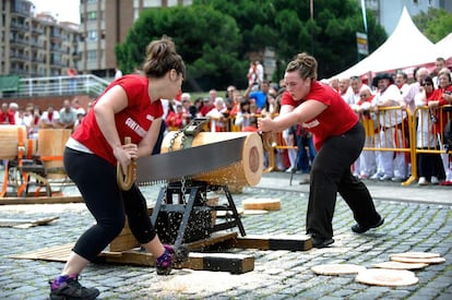 Nerea Sorondo y Amaia García cortan un tronco durante un campeonato de tronza, deporte rural vasco.