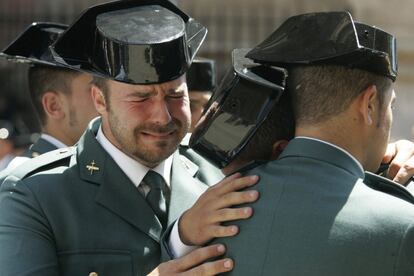 Un agente llora desconsolado mientras otros dos se abrazan, durante el funeral por los miembros de la Guardia Civil Diego Salvá y Carlos Sánez de Tejada, asesinados en un atentado de ETA en Palmanova (Mallorca), el 31 de julio de 2009. 