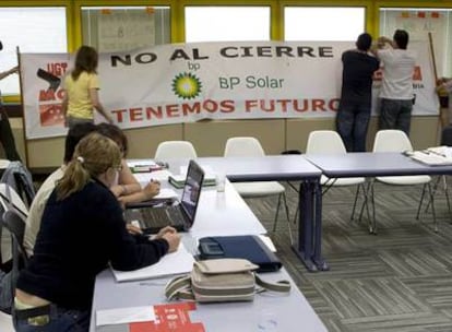 Miembros del comité de empresa de BP Solar extienden una pancarta reivindicativa.