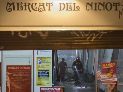 Los bomberos revisan el interior del Mercat del Ninot tras apagar el incendio.