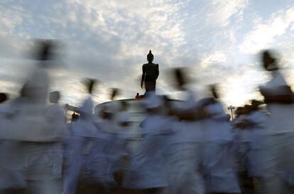 Budistas tailandeses caminan en círculo en el parque Buddhamonthon, en Bangkok (India), durante una ceremonia antes del Khao Phansa, un evento budista por el que da comienzo un periodo de tres meses en los que los monjes se encierran en sus templos a estudiar y meditar.