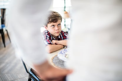 Un niño mira enfadado a un adulto.