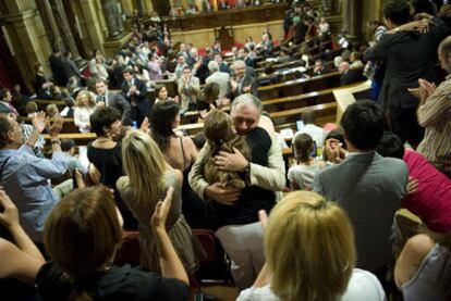 Público y diputados se felicitan en el Parlamento de Cataluña tras la aprobación de la ley.