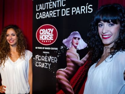 Dos de las bailarinas del cabaré parisino Crazy Horse, ayer en Barcelona junto al cartel anunciador del espectáculo.