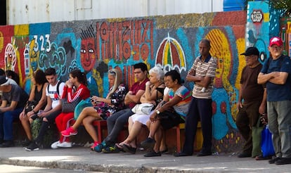 Un grupo de personas esperando en una parada de ómnibus.