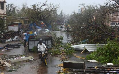 Varias personas se abren paso entre los escombros en Puri, en el estado de Odisha (India).