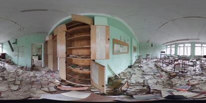 Libros y cuadernos permanecen tirados por el suelo en el aula de un colegio en la ciudad ucrania de Pripyat, el 9 de abril de 2016.