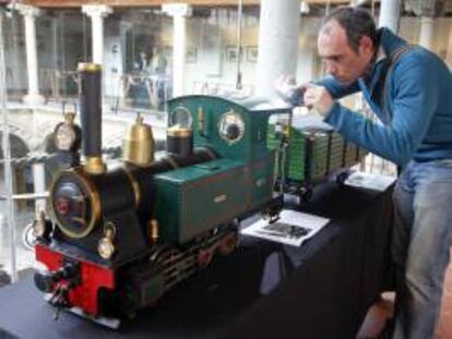 Un joven fotografía una de las maquetas que forman parte de la exposición "150 años de la llegada del ferrocarril a Ávila", inaugurada hoy en el Palacio de los Verdugo de la ciudad, con la que se inician los actos conmemorativos de esta efeméride, que tendrá su continuidad durante el mes de octubre.