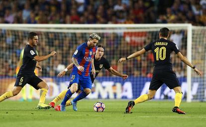 El davanter argentí del FC Barcelona Leo Messi (2i) controla la pilota entre el belga Yannick Carrasco (d), Koke Resurreción (i) i el brasiler Filipe Luís (darrere), de l'Atlètic de Madrid.