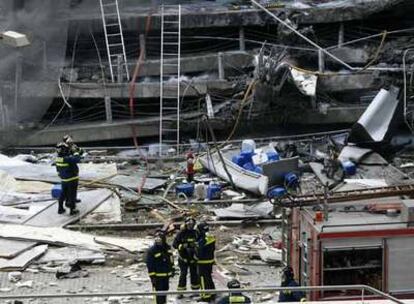 Bomberos inspeccionan el aparcamiento de Barajas tras el atentado.