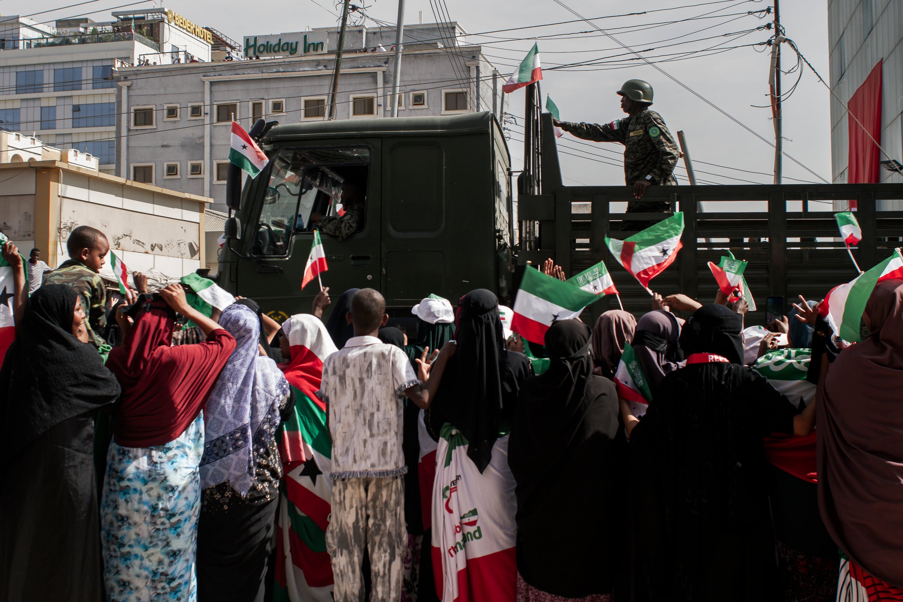 Ciudadanos de Hargeisa agitan las banderas de Somalilandia al paso de un camión militar durante el desfile del 18 de mayo.
