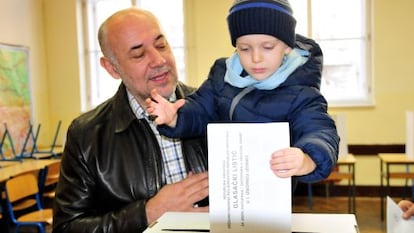 Un hombre vota con su hijo en Zagreb.