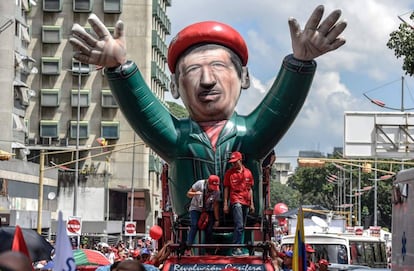 Seguidores del presidente venezolano, Nicolás Maduro, portan un inflable gigante de Chaves en Caracas, este martes.