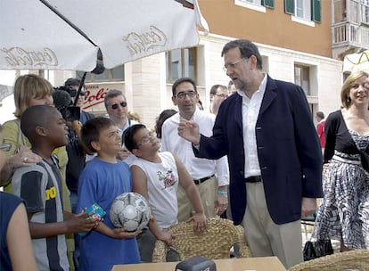 El líder del PP, Mariano Rajoy, charla con un grupo de personas durante un paseo por las calles de Menorca.