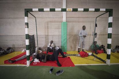 Varios migrantes subsaharianos descansan en el suelo del polideportivo de Los Cortijillos, Los Barrios, Cádiz.