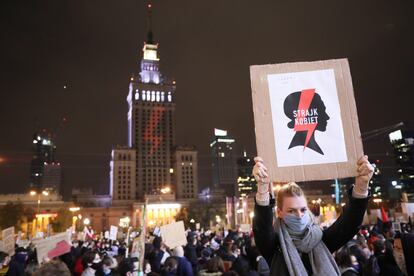 Una mujer con un cartel de la organización feminista que lidera las protestas contra el Gobierno de Polonia el viernes en una multitudinaria manifestación en Varsovia.