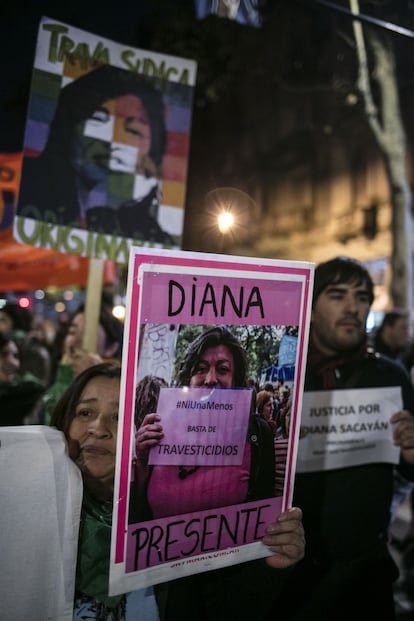 Cinco personas trans han sido asesinadas en el último año en Argentina. Una de las víctimas fue la activista Diana Sacayán, a la que hoy recordaron decenas de compañeros en el centro de Buenos Aires. Su crimen, perpetrado en el apartamento en el que vivía, fue el primero en ser caratulado como feminicidio en Argentina. Diana fue una de las impulsoras de la lucha por los derechos de las personas trans, que en 2010 celebraron la aprobación de la Ley de identidad de género, que por primera vez reconoció su identidad autopercibida."Ser travesti es una identidad que Diana llevaba adelante con orgullo como muchas otras compañeras", afirma Elena, con su rostro dibujado en una chapa que luce enganchada al abrigo. "Estoy aquí para recordar a Diana y para luchar para que nuestros cuerpos dejen de estar atravesados por las violencias. Tenemos que unirnos para pelear por la igualdad social", arenga.