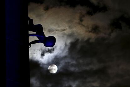 El escultor David Černý es el autor de unas esculturas de bebés que gatean por la torre de la emisora Žižkov (Praga). En la imagen, una de las figuras en una noche de luna llena.