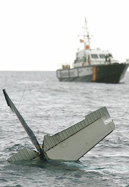 La cola de la avioneta <i>Cessna</i> permanece a flote junto a una patrullera de la Guardia Civil.