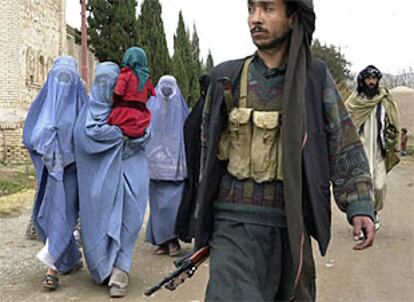 Mujeres afganas prisioneras, vestidas con el <i>burka</i>, son conducidas por sus guardianes a ser juzgadas en Herat.