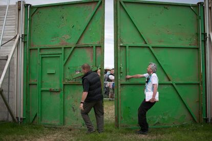 Dos trabajadores abren las puertas de la granja Worthy dando comienzo al festival Glastonbury, 25 de junio de 2014.