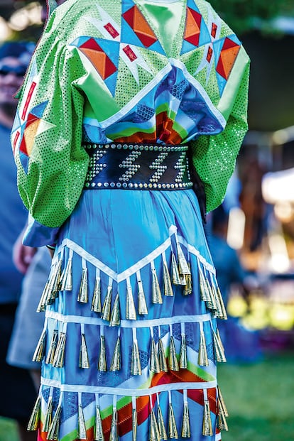 OJIBWA (ESTADOS UNIDOS). Las nativas norteamericanas de la etnia ojibwa realizan sus celebraciones vestidas con el jingle dress, del que cuelgan más de 300 campanillas cónicas. En su día, los conos empleados se reciclaban de la tapa metálica de las latas de tabaco en hebras. Como calzado utilizan botas coloridas y en ocasiones mocasines, pues ellos presumen de ser los inventores de este tipo de calzado.