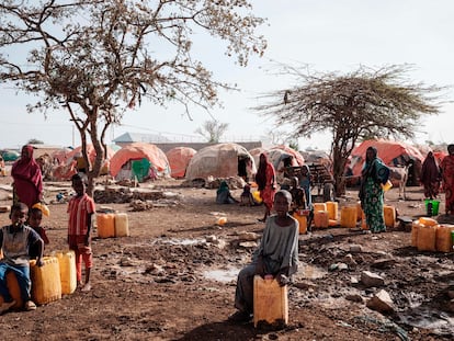 La gente espera a coger agua con contenedores en un campamento para desplazados en Baidoa (Somalia), en febrero de 2022.
