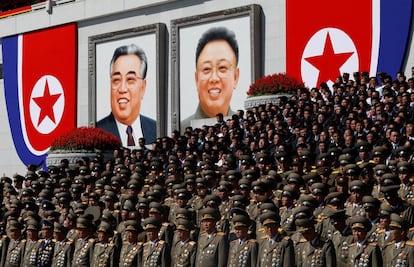 Os retratos dos líderes norte-coreanos, Kim Il Sung e Kim Jong Il, ao fundo de um desfile de altos servidores públicos militares na praça Kim Il Sung de Pyonyang.