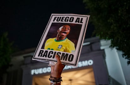 Un manifestante levanta un cartel con la imagen de Vinicus Júnior y la frase "Lucha contra el racismo", durante una protesta en São Paulo.